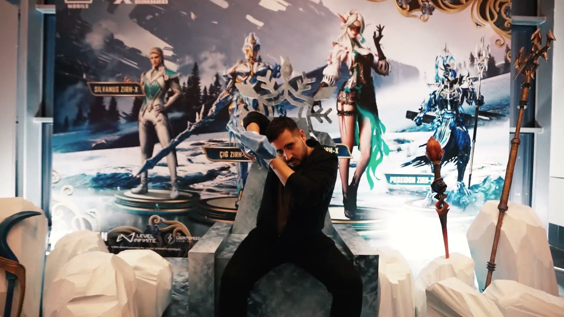 A man seated on a prop ice throne before a PUBG Mobile character backdrop